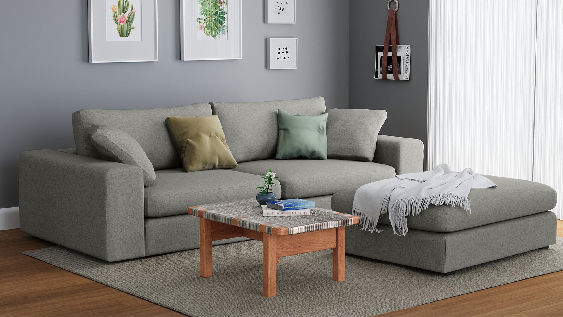 A gray Titan Libby sofa and ottoman placed in a cozy living room setting with decorative pillows, a wooden coffee table, and a large wall art.